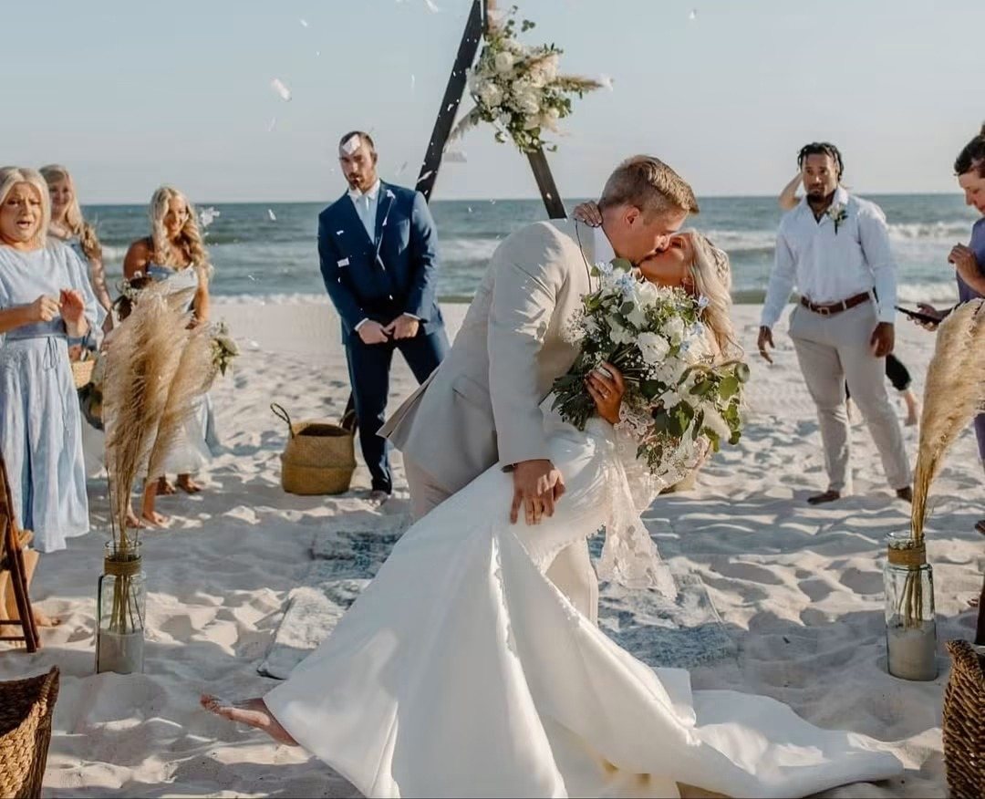 Beach ceremony with pampas grass and a bride in the sand