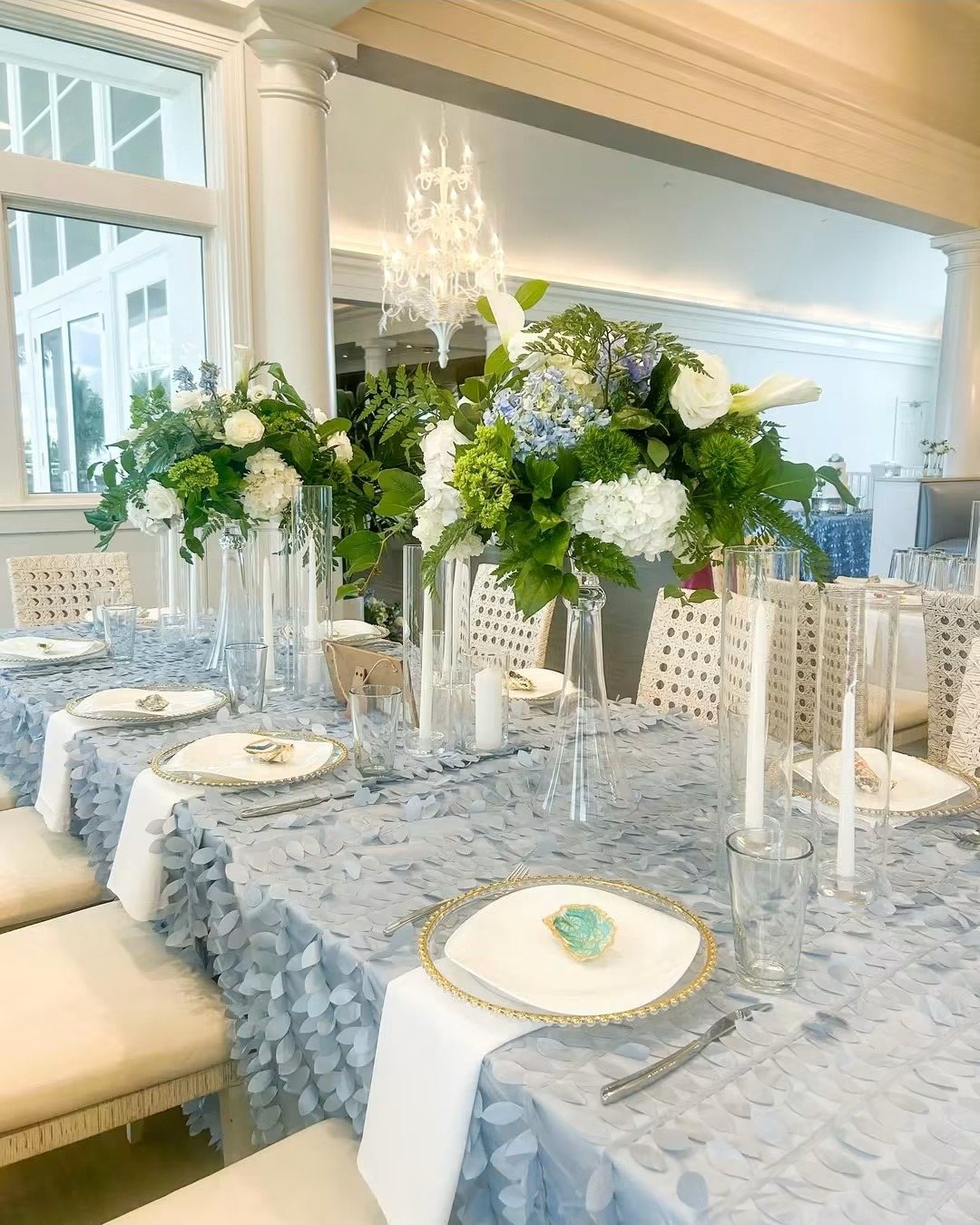 Blue linens, white florals and a crystal chandelier
