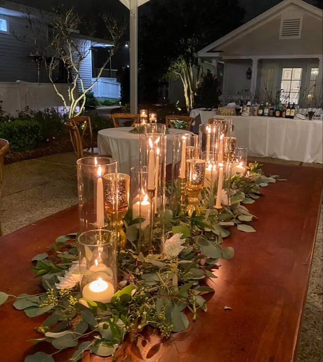 Candle and greenery runner on a table at night